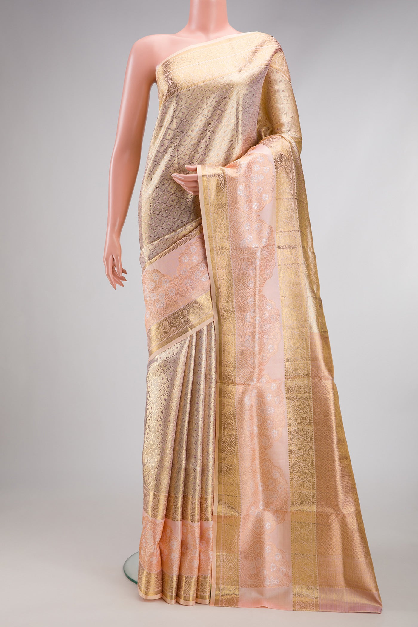 Gold Dual Tone Kanjivaram Tissue Silk Saree with Zari Brocade on the body and Fancy Border.  displayed on a mannequin