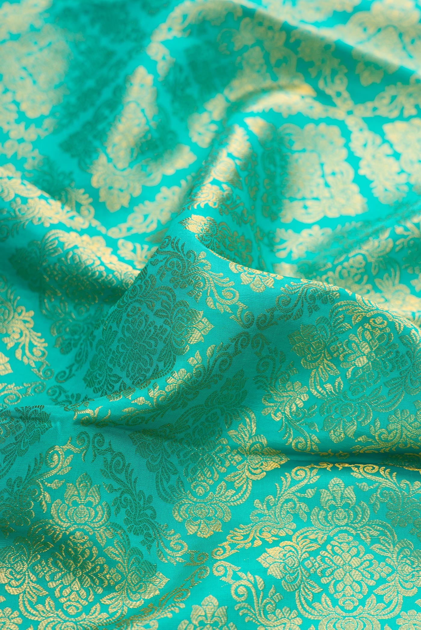 Close up of Sea Green Dual Tone Kanchipuram Silk Saree with Zari Brocade on the body and Zari Border.  displaying folds