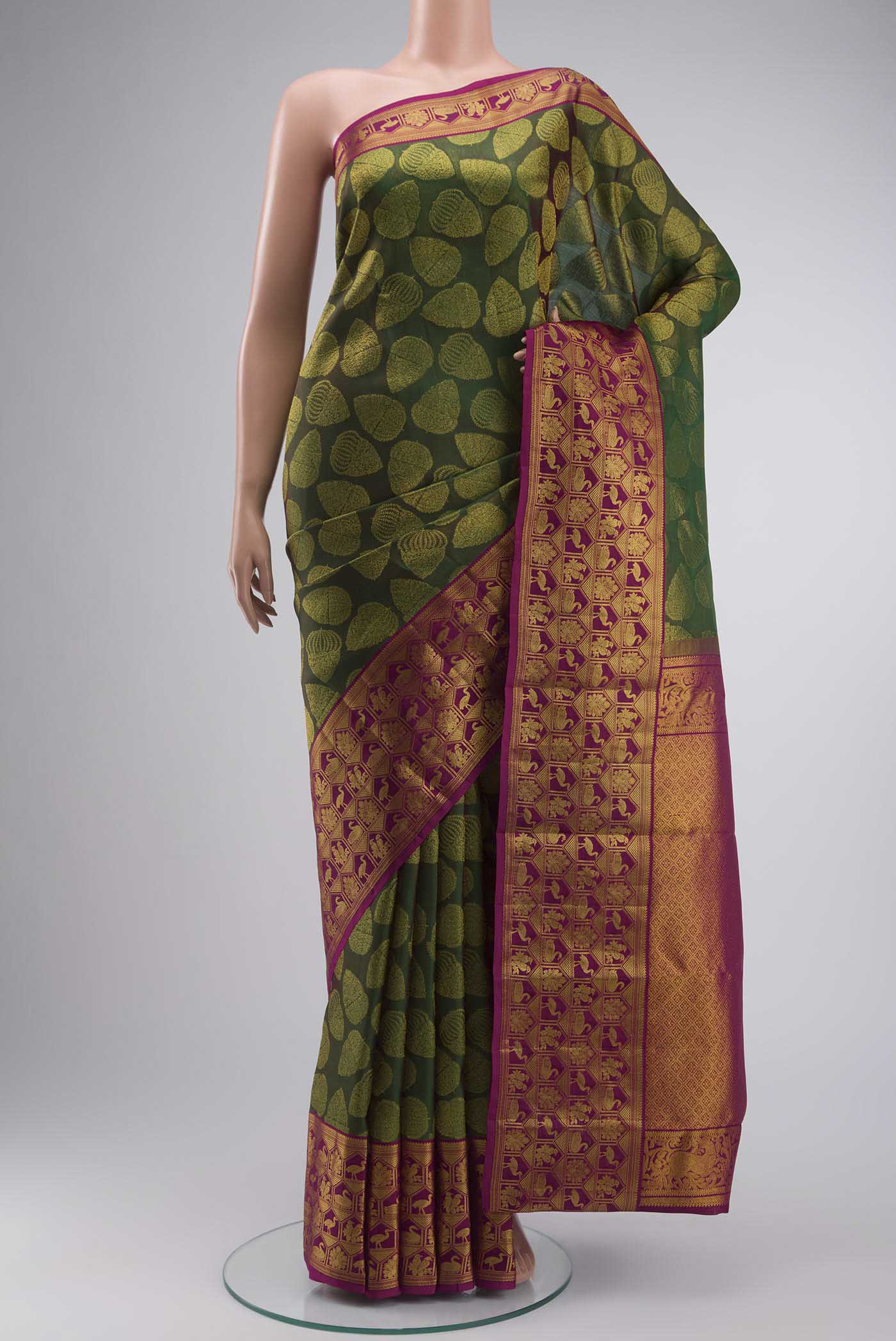 Green Kanchipuram Silk Saree with Zari Butta on the body and Zari Border displayed on a mannequin