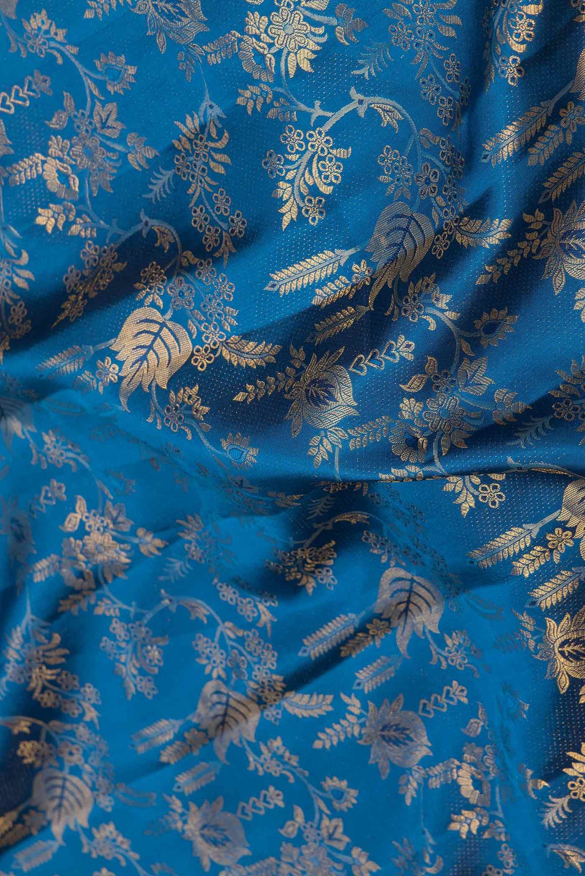 Close up of Peacock Blue Dual Tone Kanchipuram Saree with Zari Brocade on the body and Zari Border displaying folds