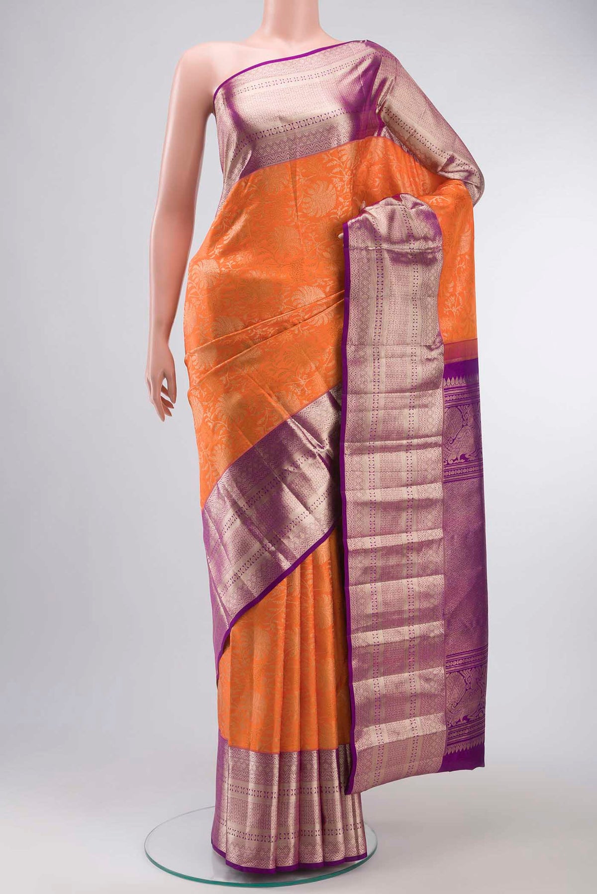 Orange Kanchipuram Silk Saree with Zari Brocade on the body and Zari Border displayed on a mannequin
