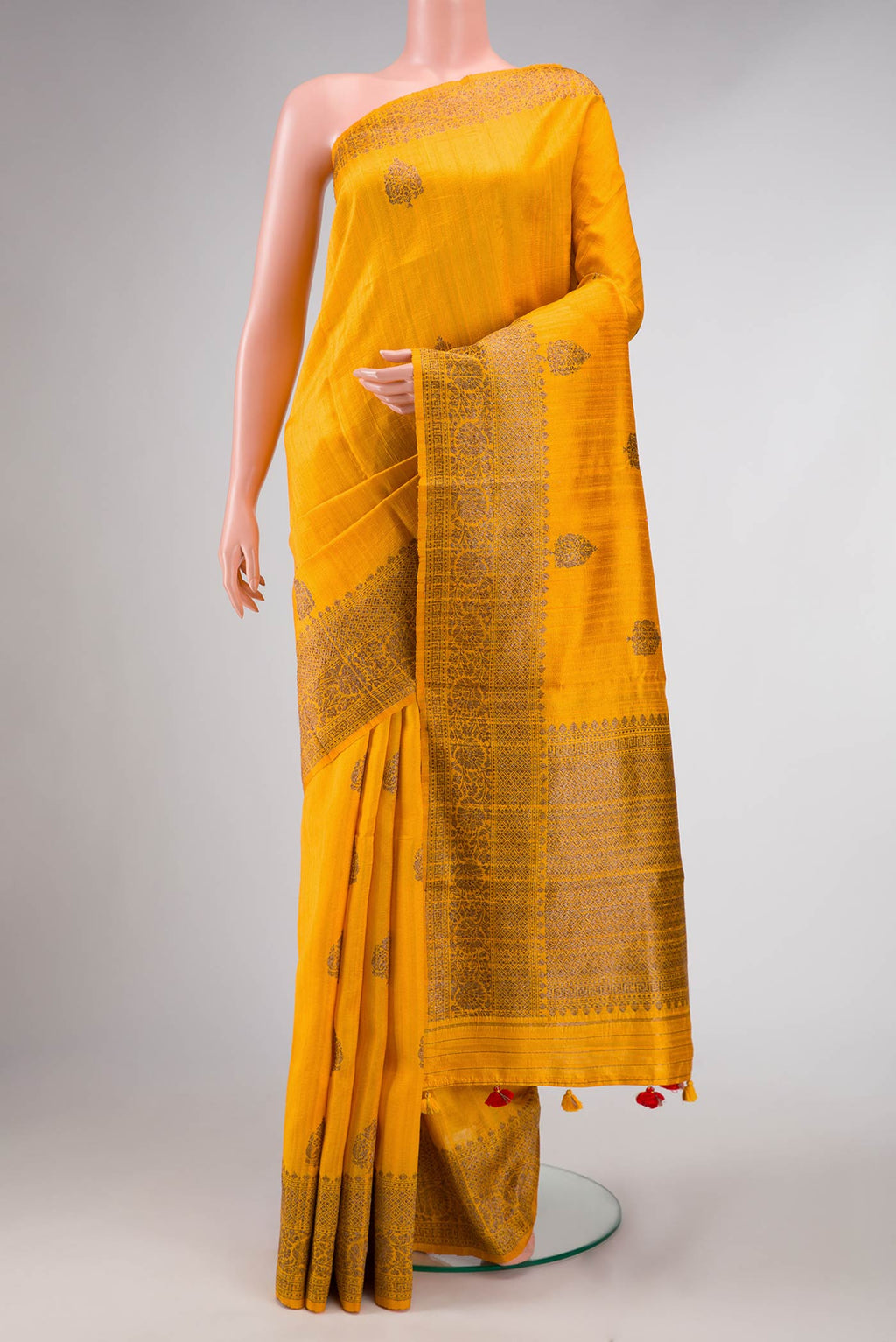 Mustard Dual Tone Raw Silk Saree with Zari Butta on the body and Zari Border displayed on a mannequin