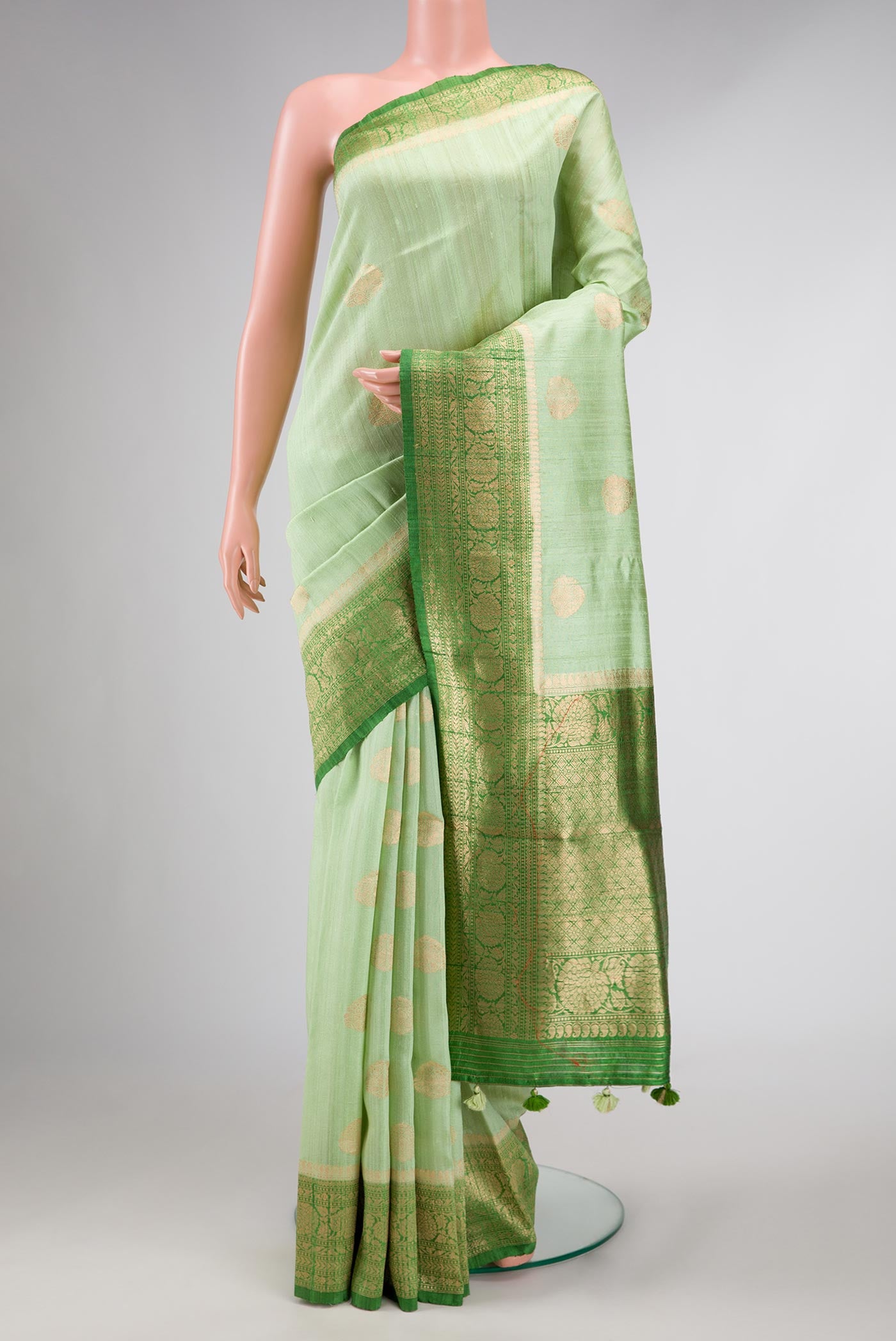 Light Green Dual Tone Raw Silk Saree with Zari Butta on the body and Zari Border displayed on a mannequin