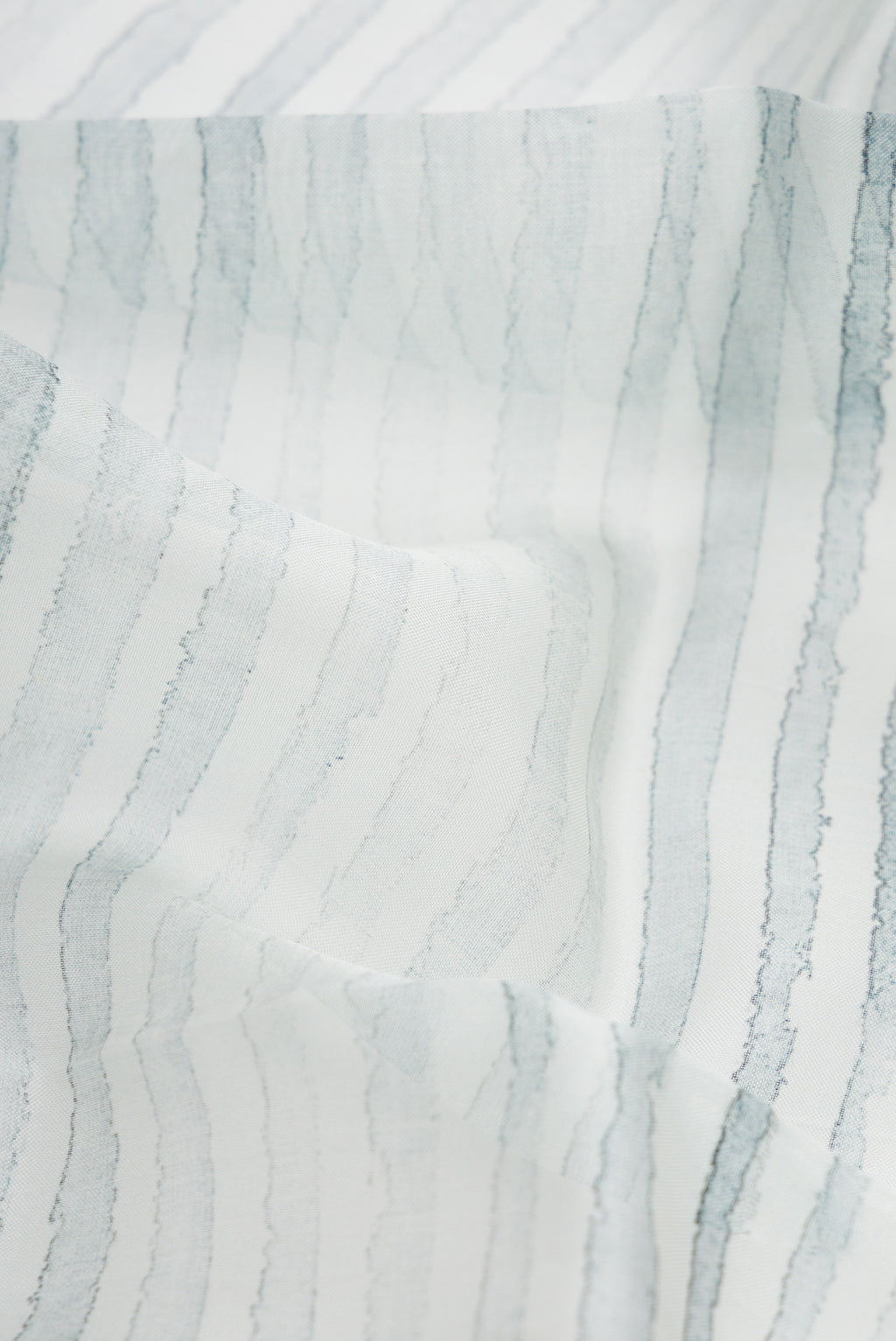 Close up of Grey Dual Tone Organza Silk Saree with Printed design on the body and Zari Border.  displaying folds