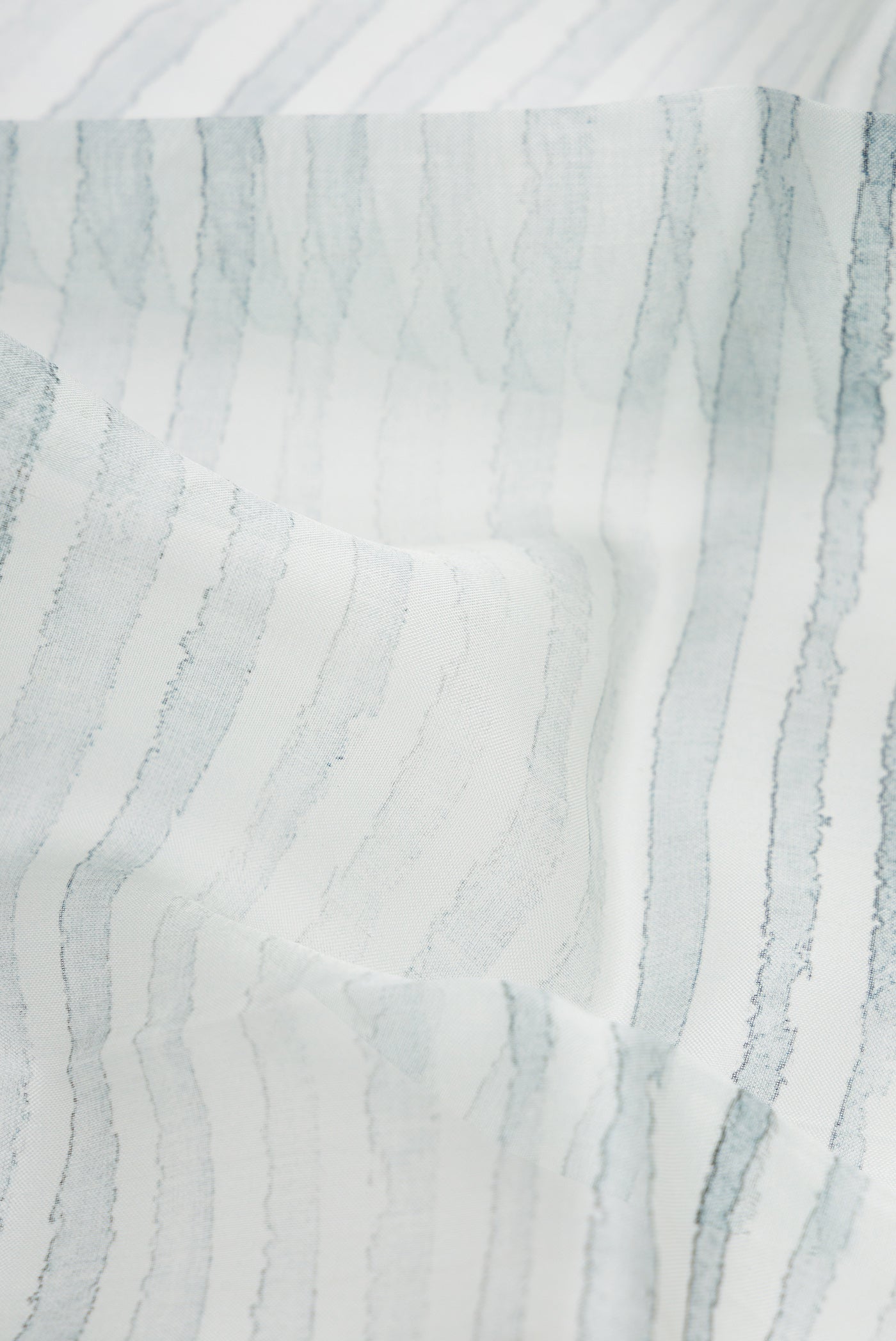 Close up of Grey Dual Tone Organza Silk Saree with Printed design on the body and Zari Border.  displaying folds