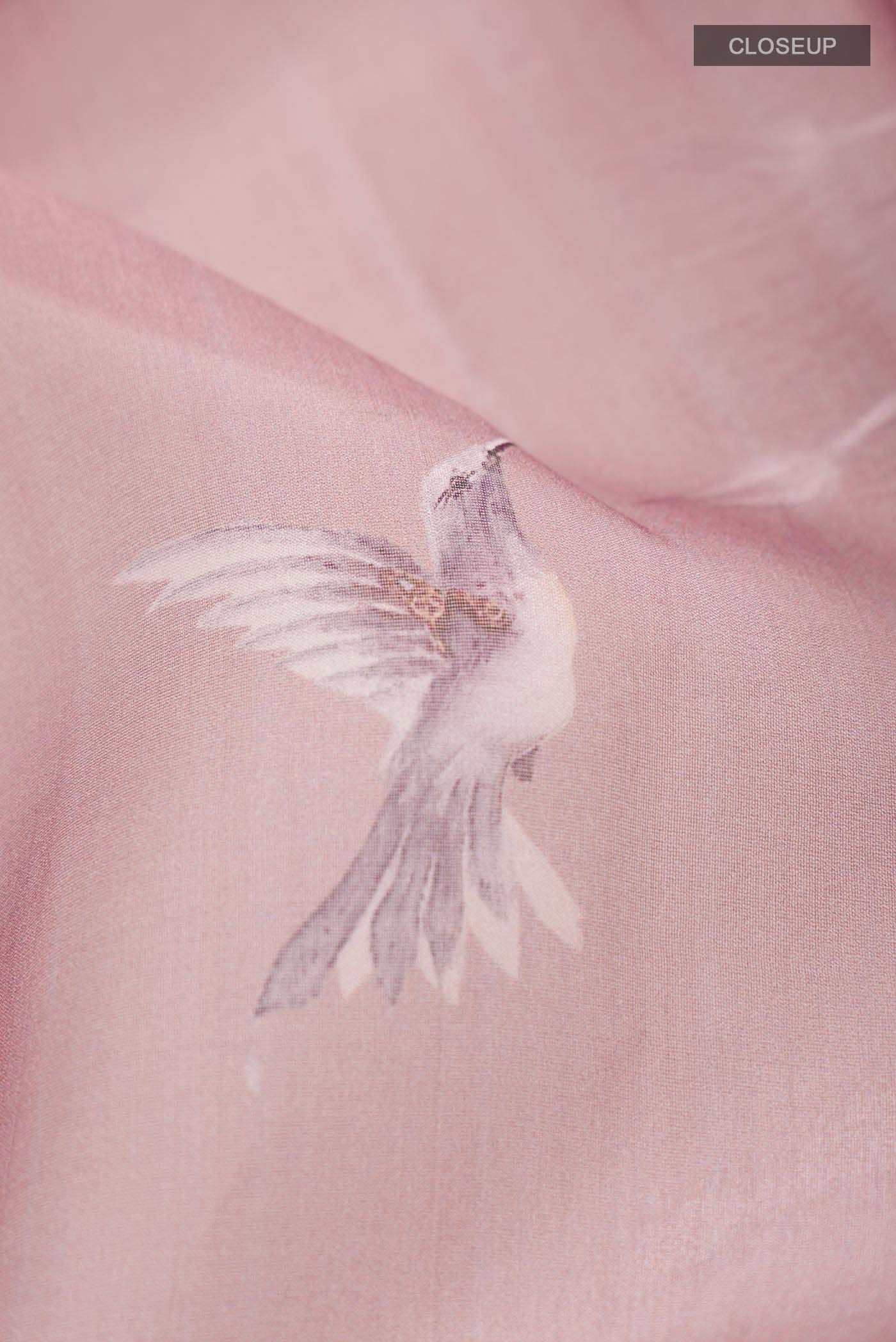 Close up of Mauve Organza Silk Saree with Floral Print on the body and Zari Border displaying folds