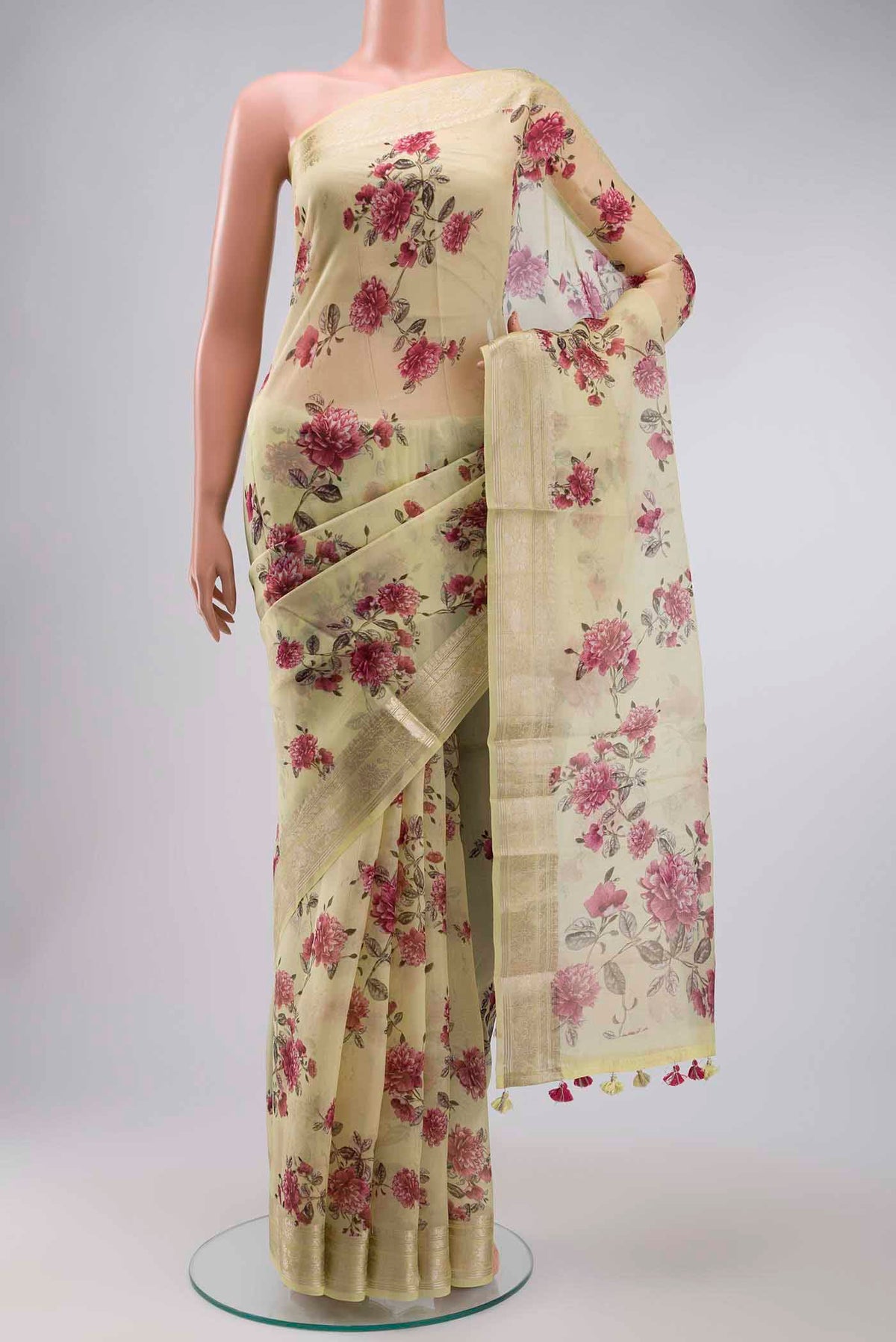 Yellow Organza Silk Saree with Printed design on the body and Zari Border displayed on a mannequin