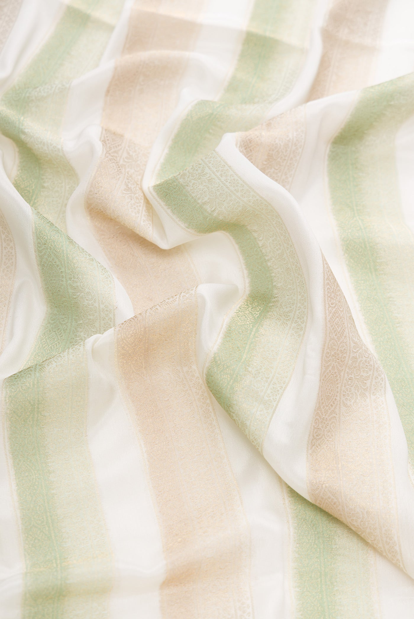 Close up of Offwhite , Green and Beige Color Mysore Silk Saree with Stripes on the body and Zari Border.  displaying folds