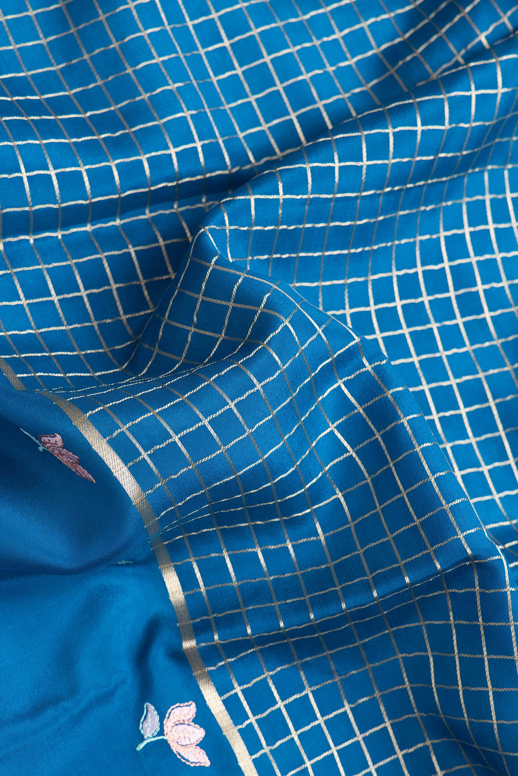 Close up of Peacock Blue Dual Tone Mysore Silk Saree with Checked design on the body and Embroidery Border.  displaying folds