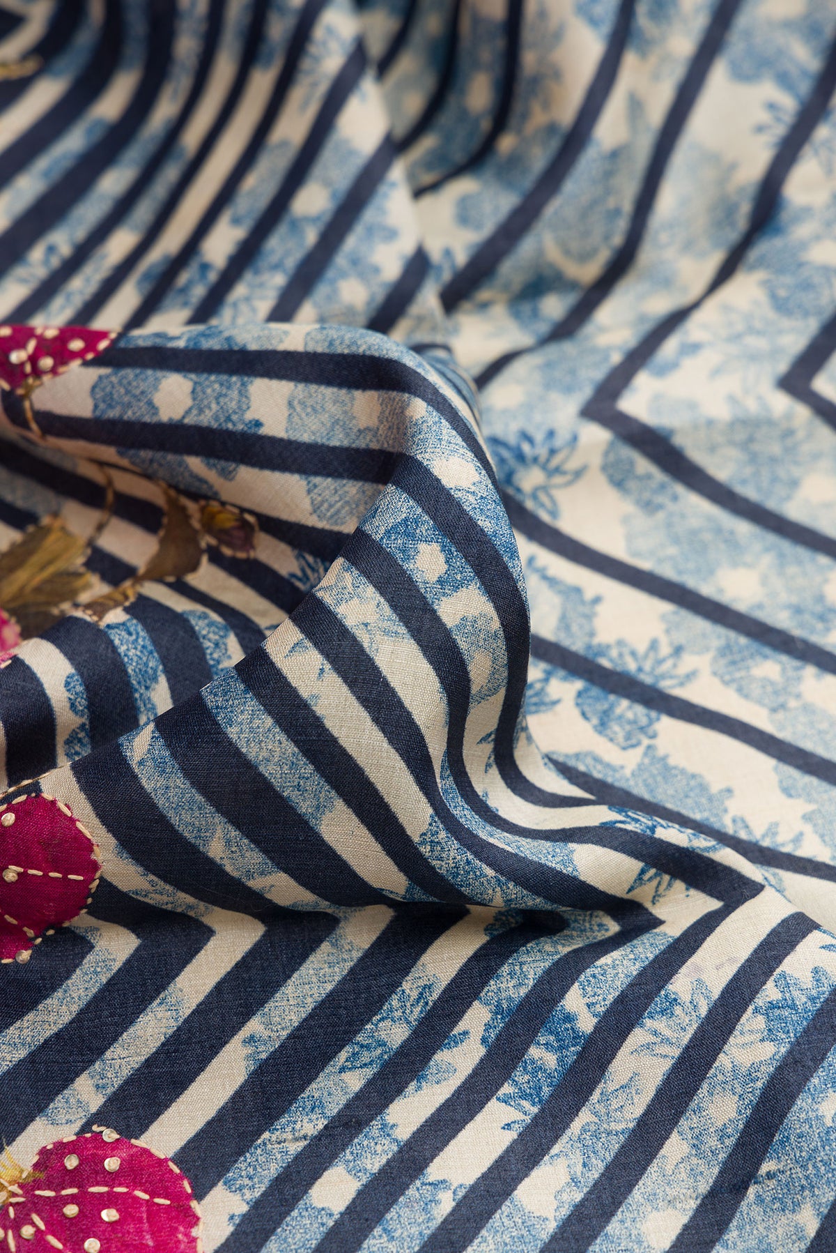 Close up of Grey Dual Tone Tussar Silk Saree with Printed design on the body and Embroidery Border.  displaying folds
