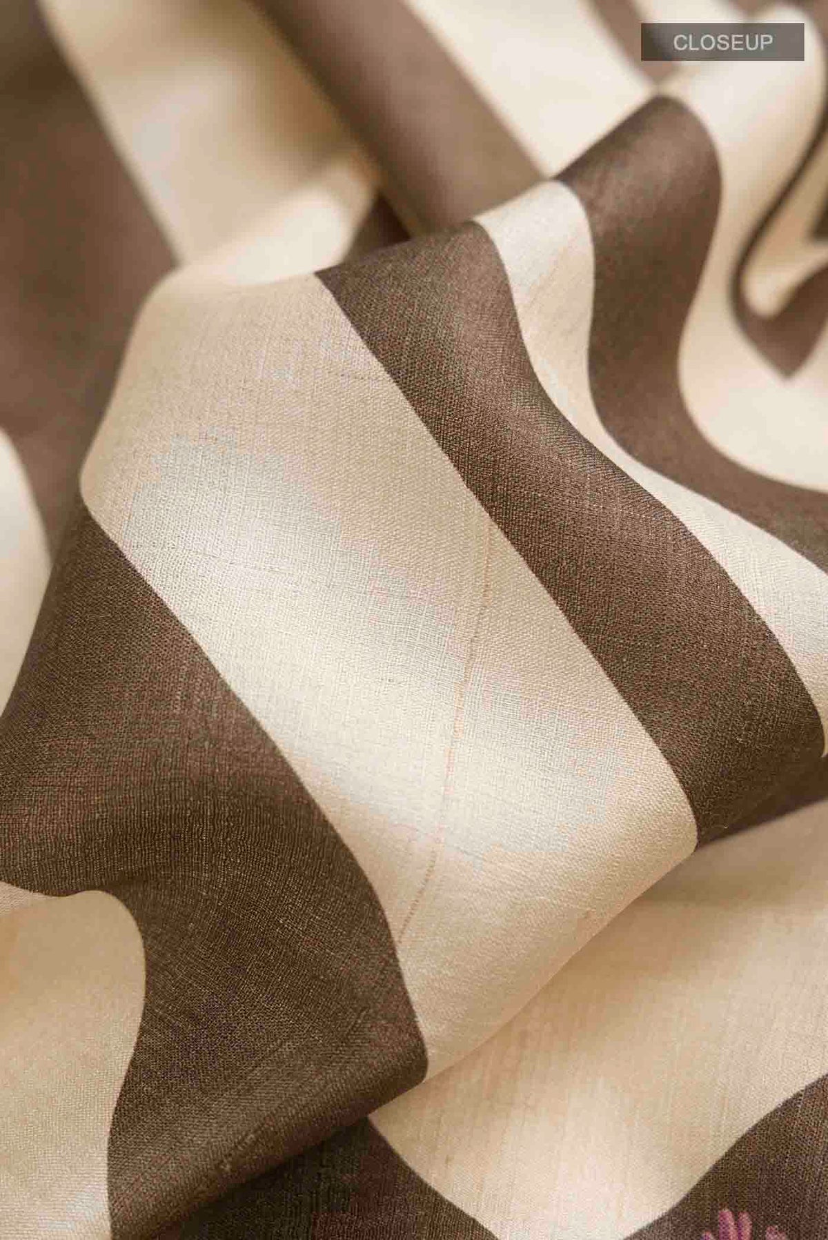 Close up of Brown Bhagalpuri Tussar Silk Saree with Embroidery on the body and Zari Border displaying folds