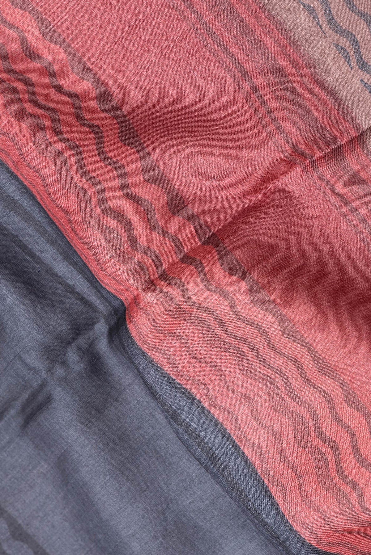 Close up of Navy Blue Dual Tone Tussar Silk Saree with Printed design on the body and Embroidery Border.  displaying folds