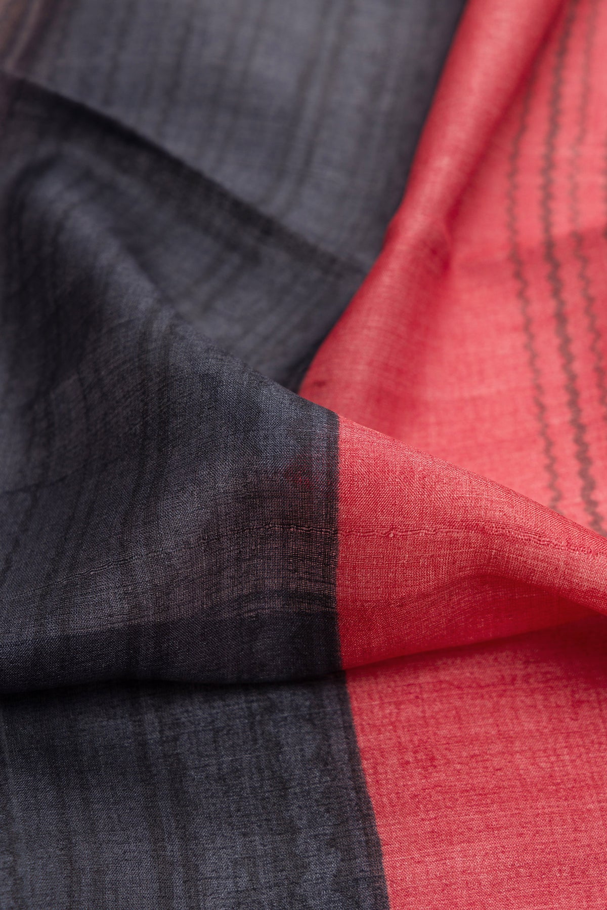 Close up of Maroon,Brown and Black Color Tussar Silk Saree with Printed design on the body and Embroidery Border.  displaying folds