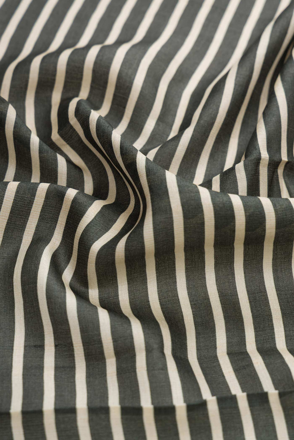 Close up of Green Dual Tone Tussar Silk Saree with Stripes on the body and Fancy Border displaying folds