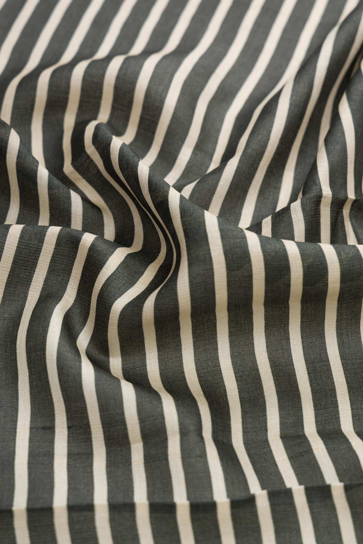 Close up of Green Dual Tone Tussar Silk Saree with Stripes on the body and Fancy Border displaying folds