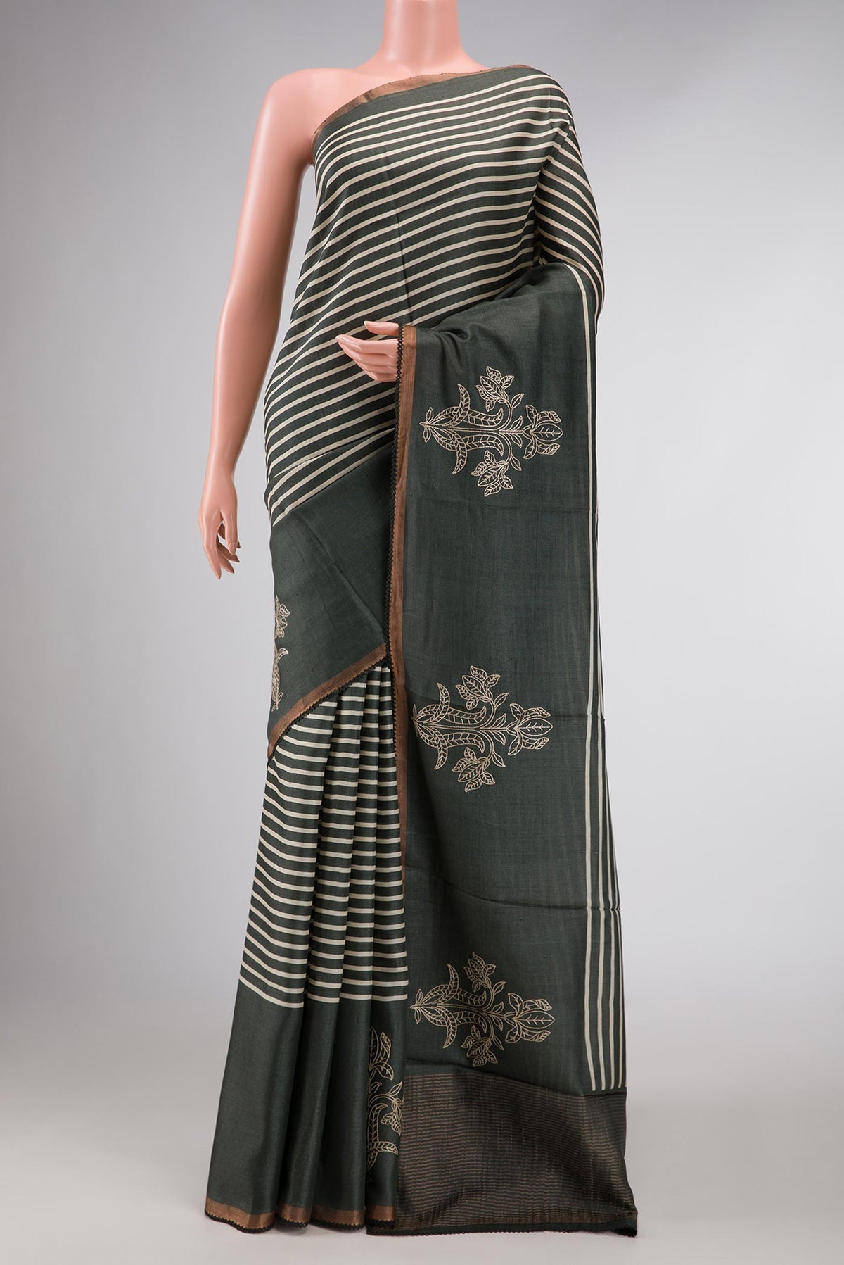 Green Dual Tone Tussar Silk Saree with Stripes on the body and Fancy Border displayed on a mannequin