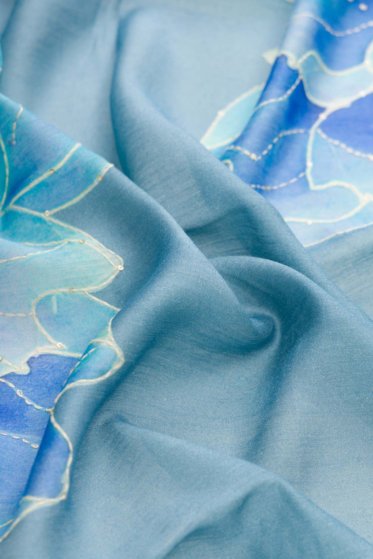 Close up of Blue Dual Tone Tussar Silk Saree with Printed design on the body and Zari Border displaying folds