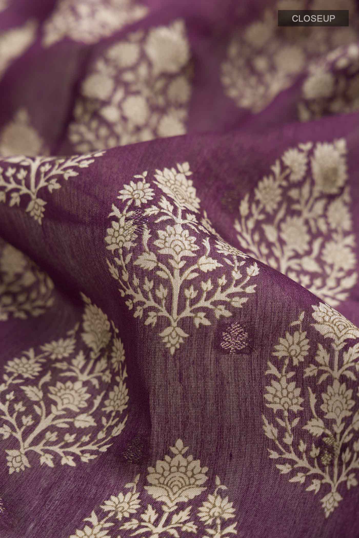 Close up of Mauve Tussar Silk Saree with Printed design on the body and Zari Border displaying folds