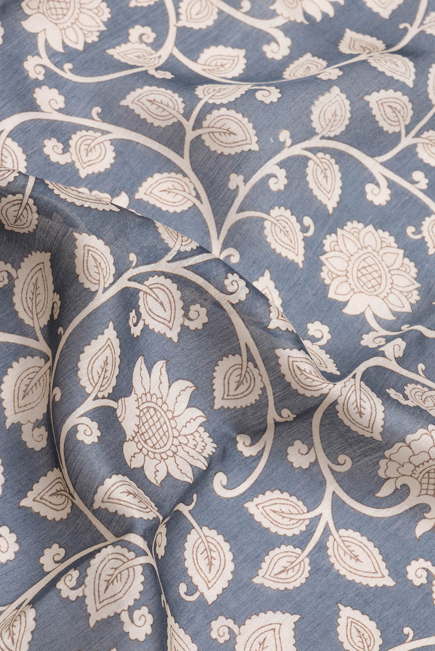 Close up of Grey Dual Tone Tussar Silk Saree with Printed design on the body and Zari And Thread Border.  displaying folds