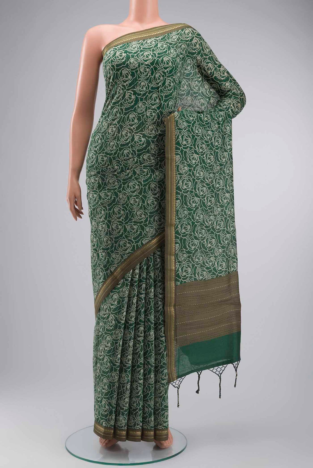Green Tussar Silk Saree with Printed design on the body and Zari Border displayed on a mannequin