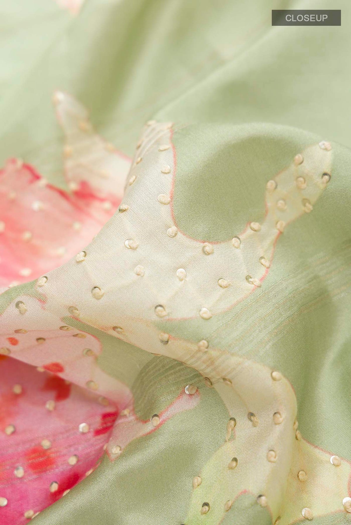 Close up of Green Tussar Silk Saree with Embroidery on the body and Zari Border displaying folds
