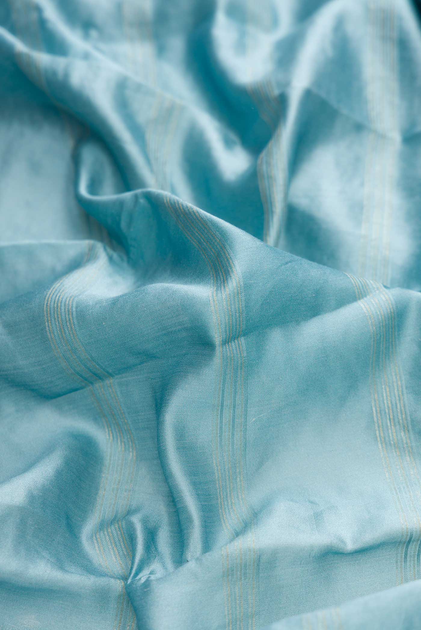 Close up of Light Blue Dual Tone Tussar Silk Saree with Embroidery on the body and Zari Border displaying folds