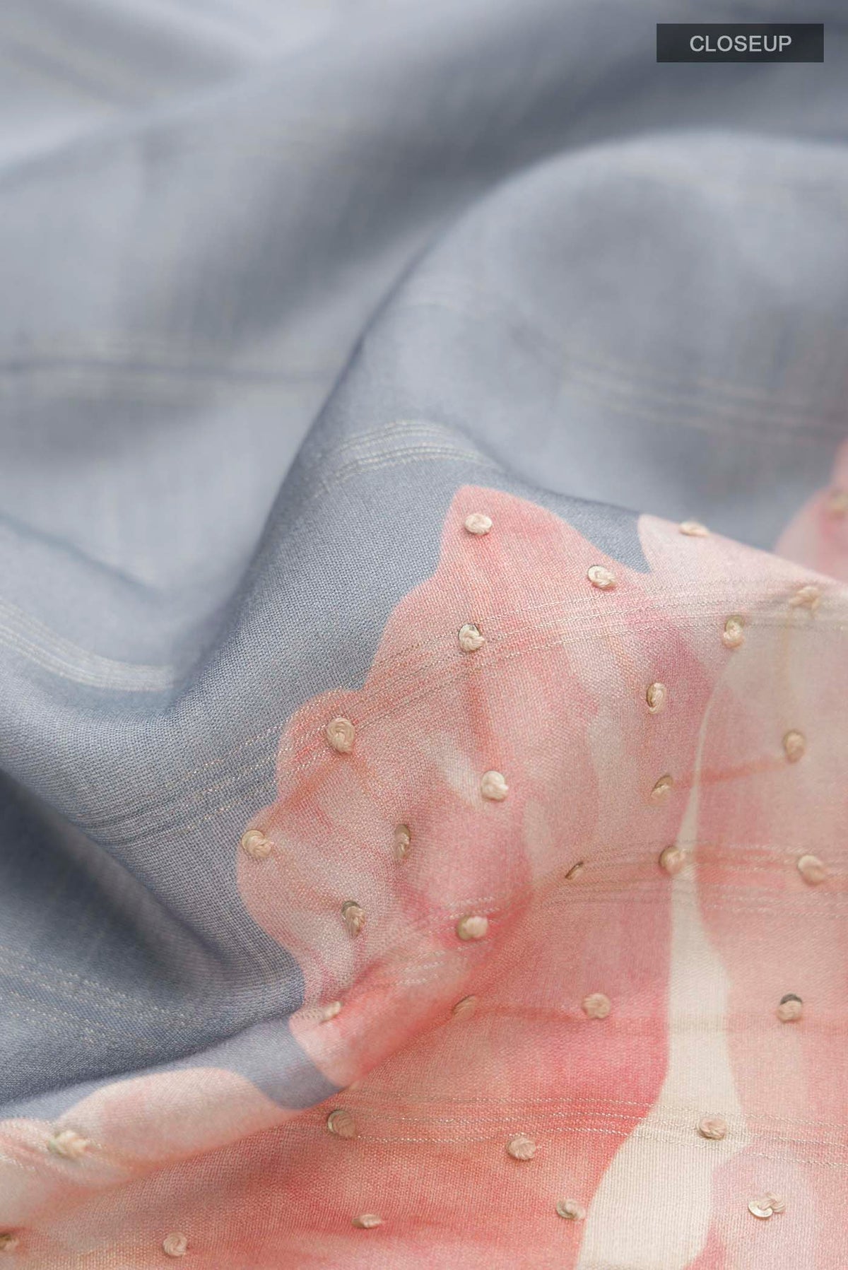 Close up of Grey Tussar Silk Saree with Embroidery on the body and Zari Border displaying folds