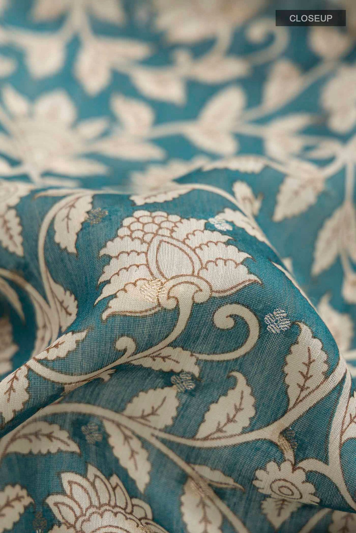 Close up of Blue Bhagalpuri Tussar Silk Saree with Printed design on the body and Zari Border displaying folds