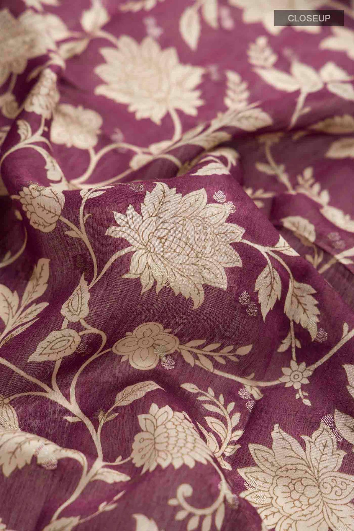 Close up of Purple Tussar Silk Saree with Printed design on the body and Zari Border displaying folds