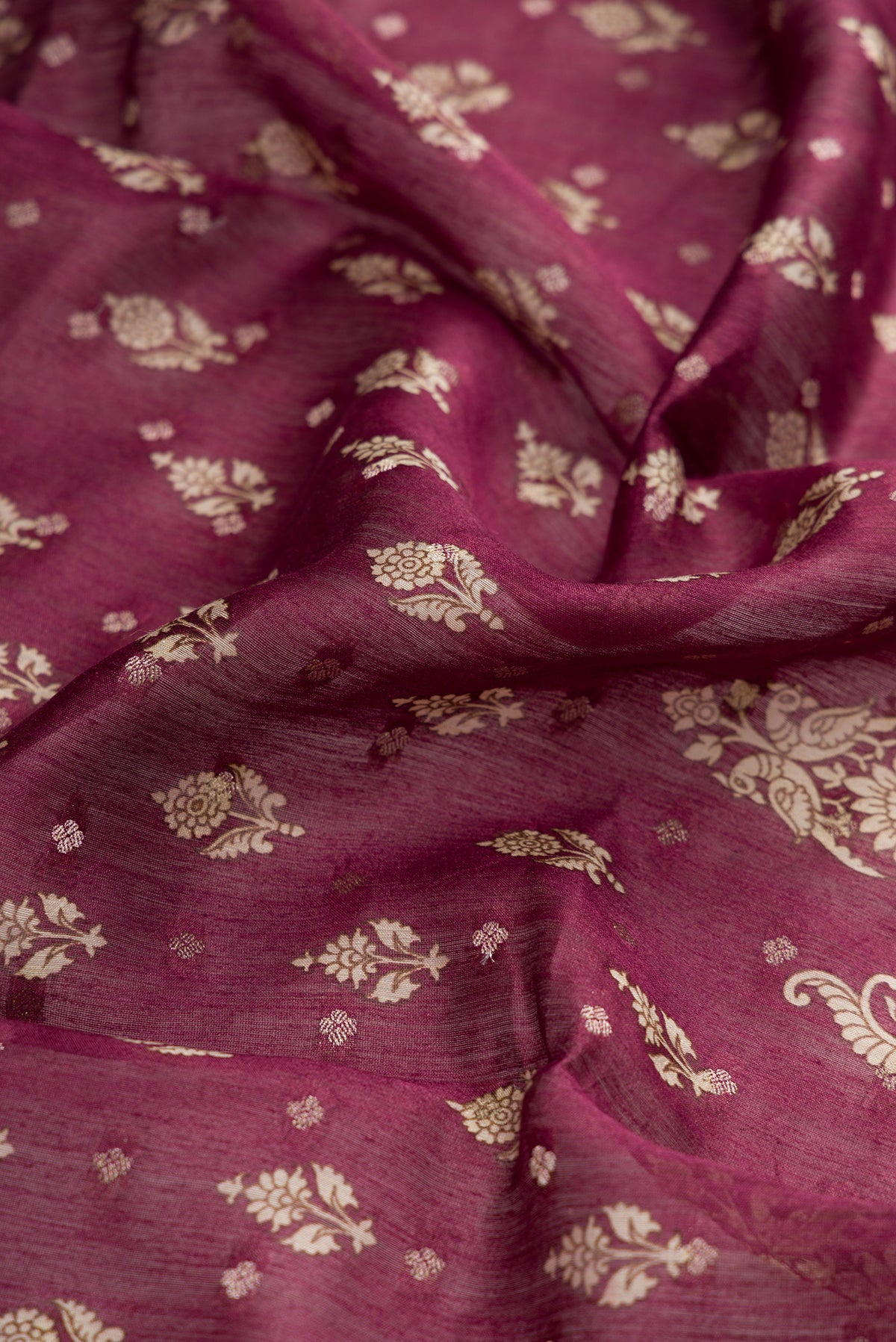Close up of Burgundy Dual Tone Tussar Silk Saree with Printed design on the body and Zari Border.  displaying folds