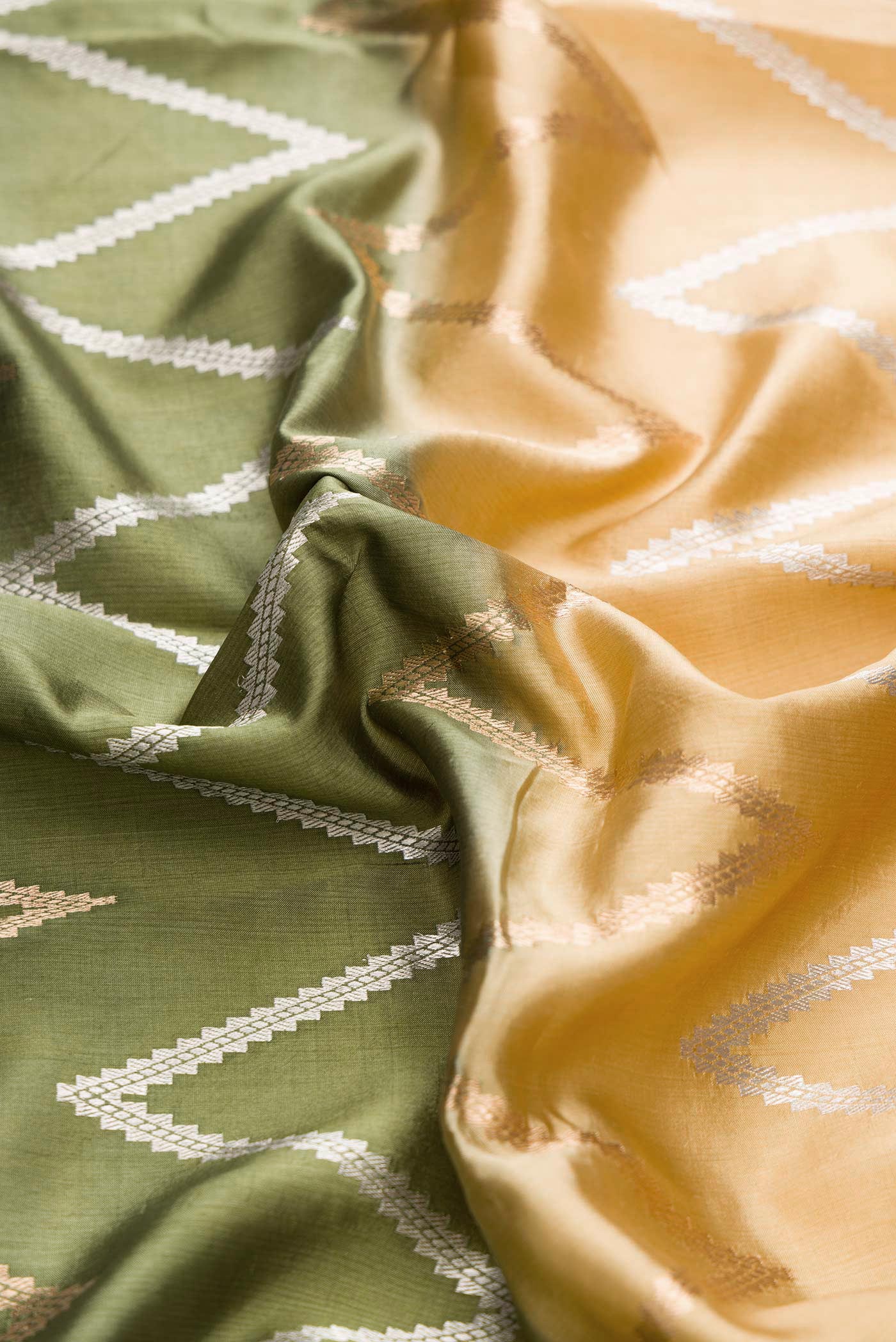 Close up of Green and Sandal Color Tussar Silk Saree with Zari Butta on the body and Plain Border displaying folds