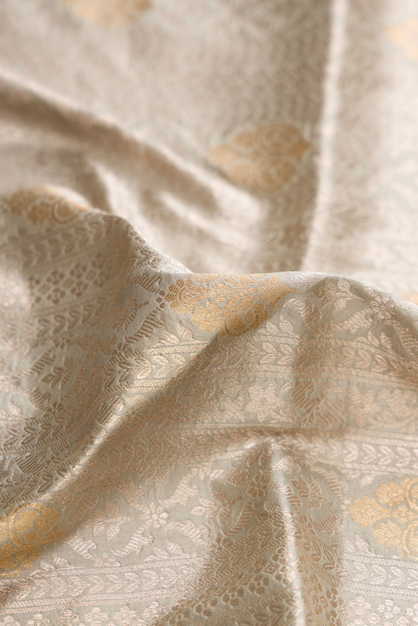 Close up of Grey Dual Tone Banarasi Silk Saree with Zari Brocade on the body and Zari Border.  displaying folds