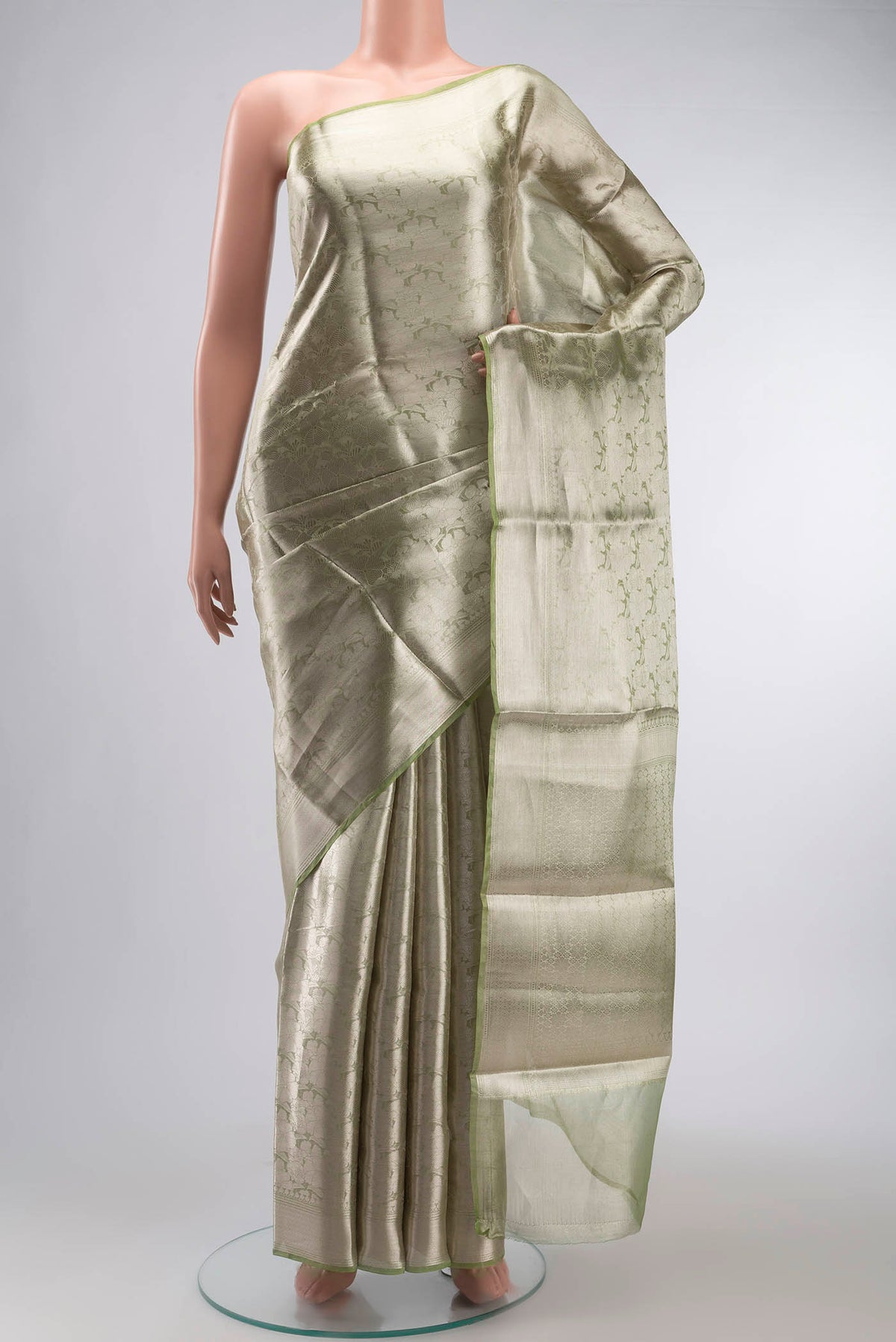Green Tissue Silk Saree with Zari Brocade on the body and Zari Border displayed on a mannequin