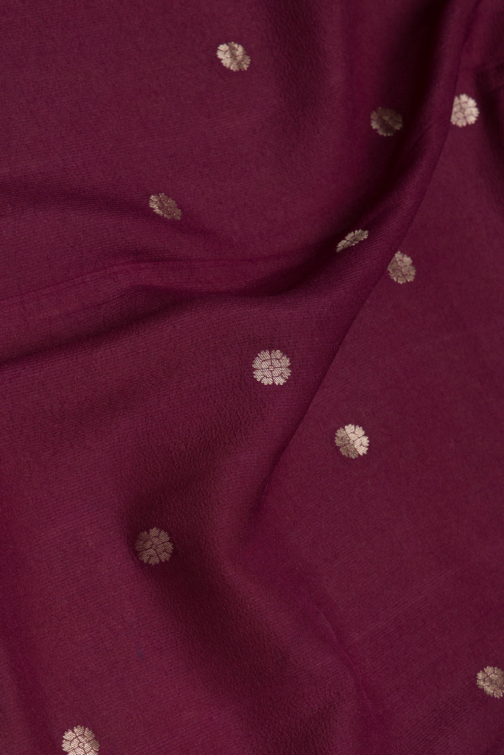 Close up of Maroon Dual Tone Tussar Silk Saree with Zari Butta on the body and Zari Border.  displaying folds