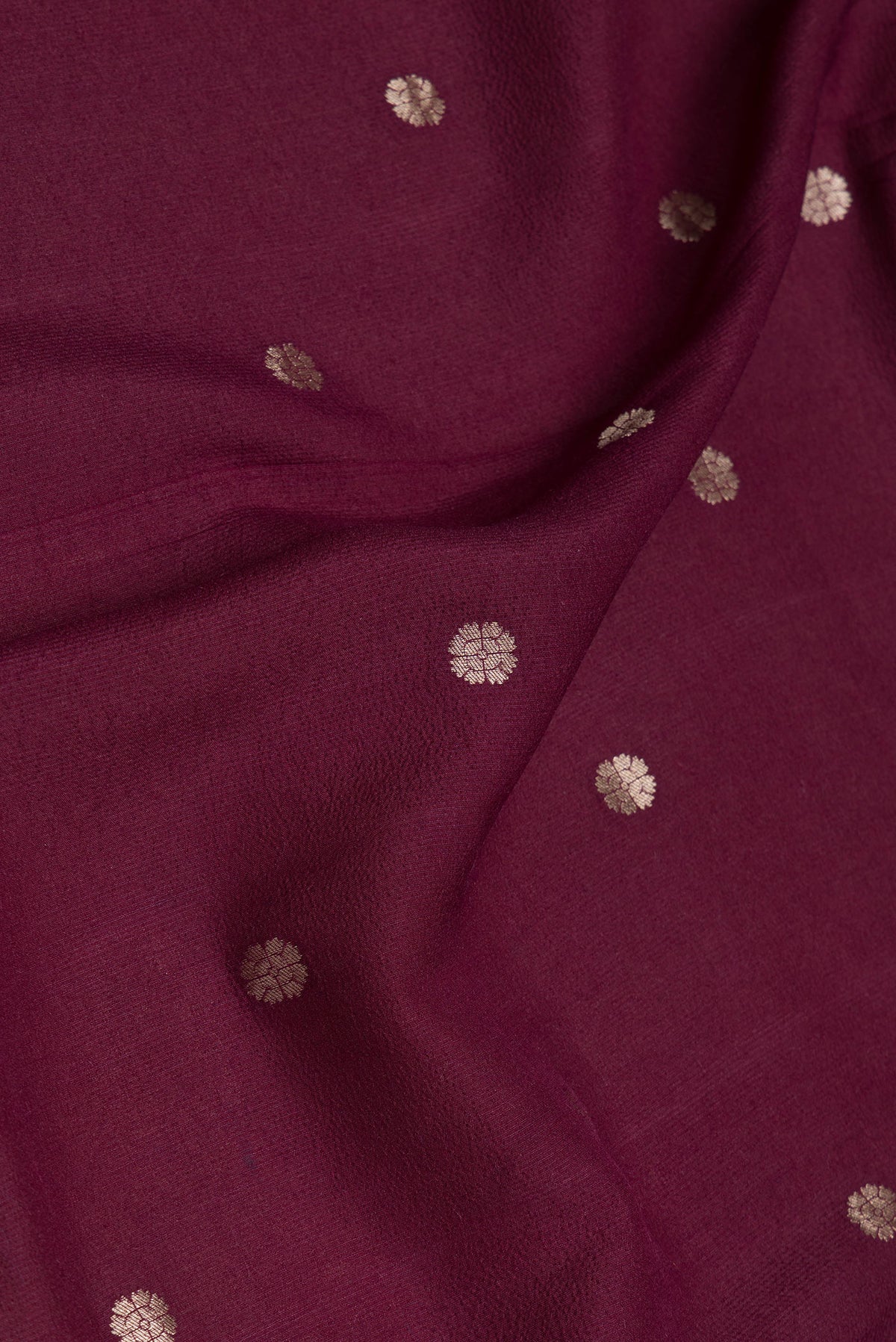 Close up of Maroon Dual Tone Tussar Silk Saree with Zari Butta on the body and Zari Border.  displaying folds