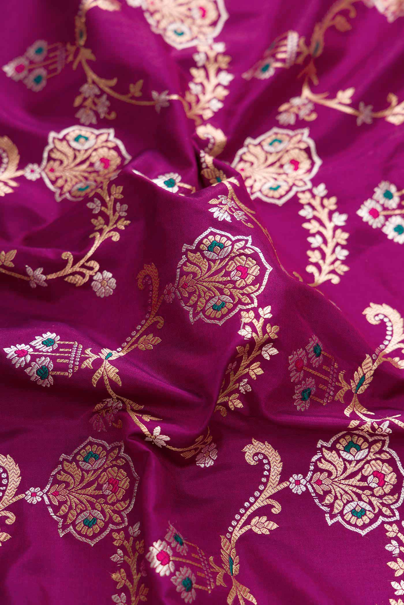 Close up of Magenta Dual Tone Banarasi Silk Saree with Zari And Thread Butta on the body and Zari Border displaying folds