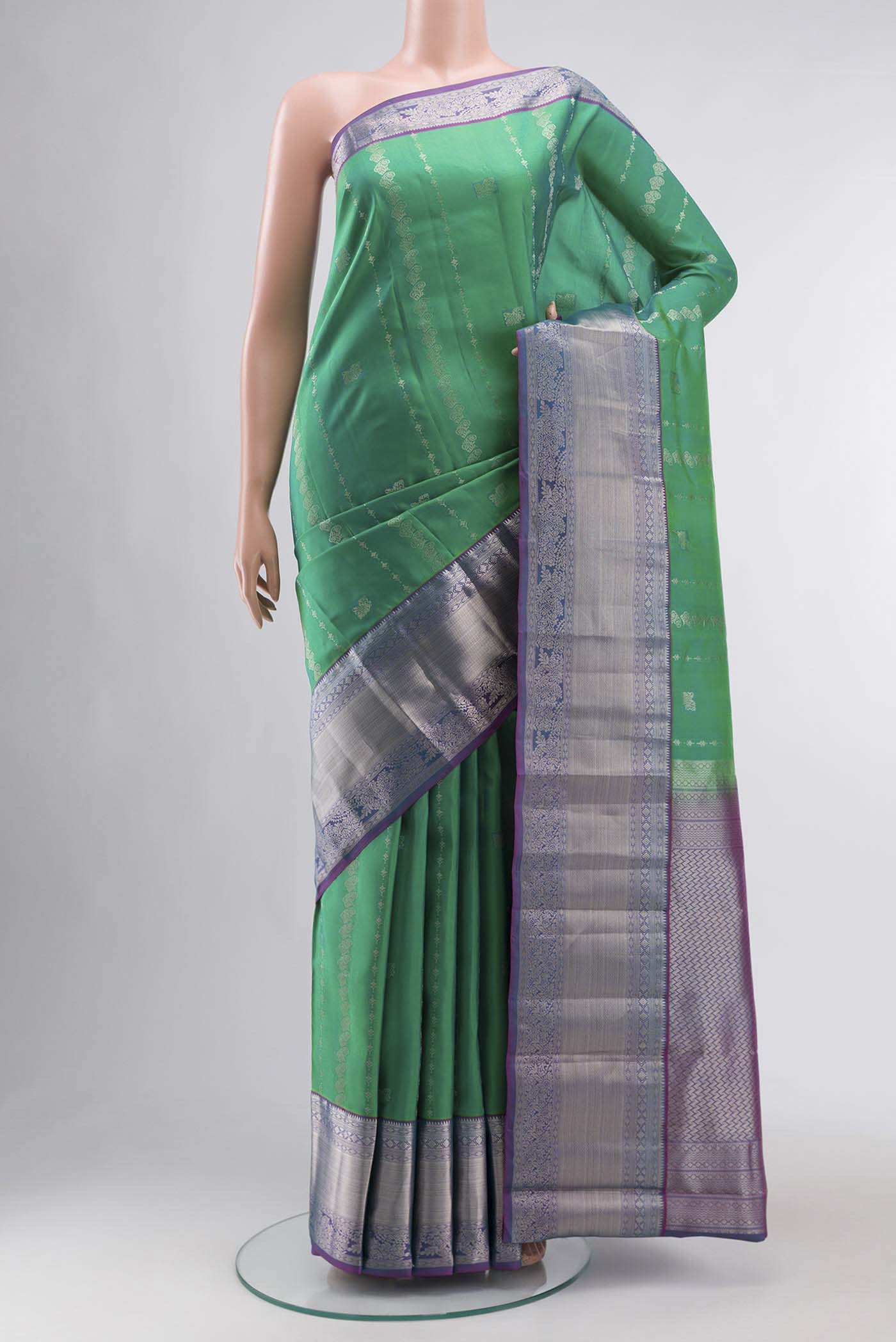 Green Kanchipuram Silk Saree with Zari Butta on the body and Zari Border displayed on a mannequin