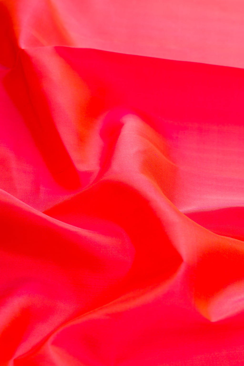 Close up of Coral Dual Tone Kanchipuram Silk Saree with Plain Body and Ganga Jamuna Border.  displaying folds