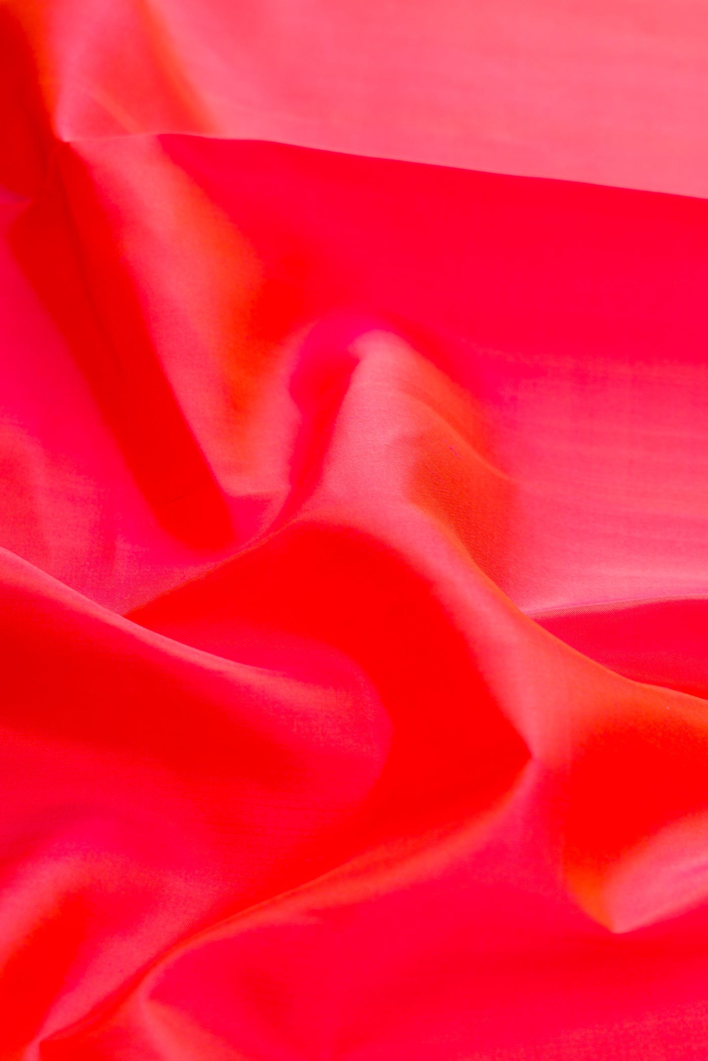 Close up of Coral Dual Tone Kanchipuram Silk Saree with Plain Body and Ganga Jamuna Border.  displaying folds