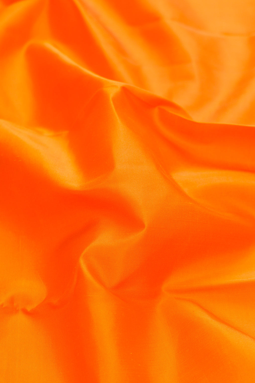 Close up of Orange Dual Tone Kanchipuram Silk Saree with Plain Body and Ganga Jamuna Border.  displaying folds