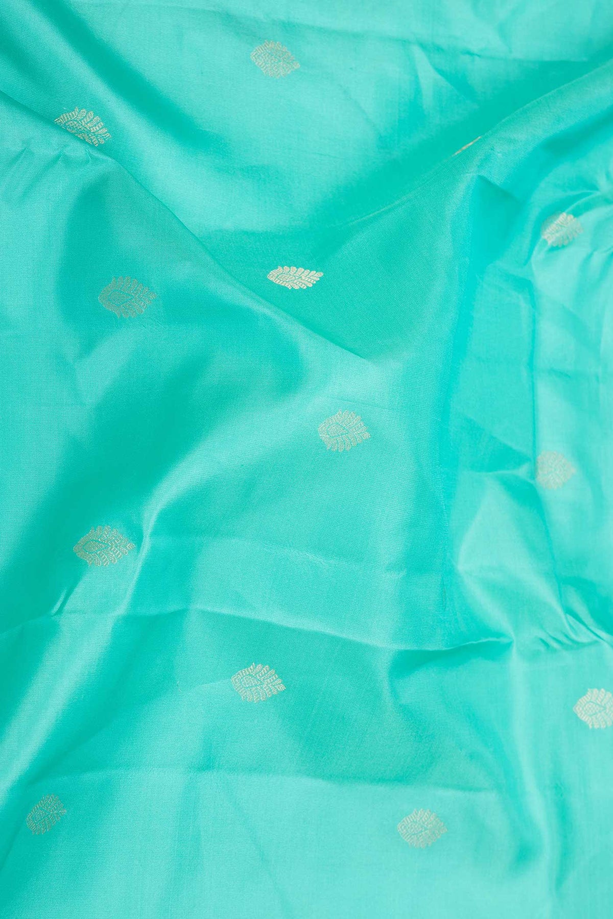Close up of Sea Green Dual Tone Kanchipuram Saree with Zari Butta on the body and Zari Border displaying folds
