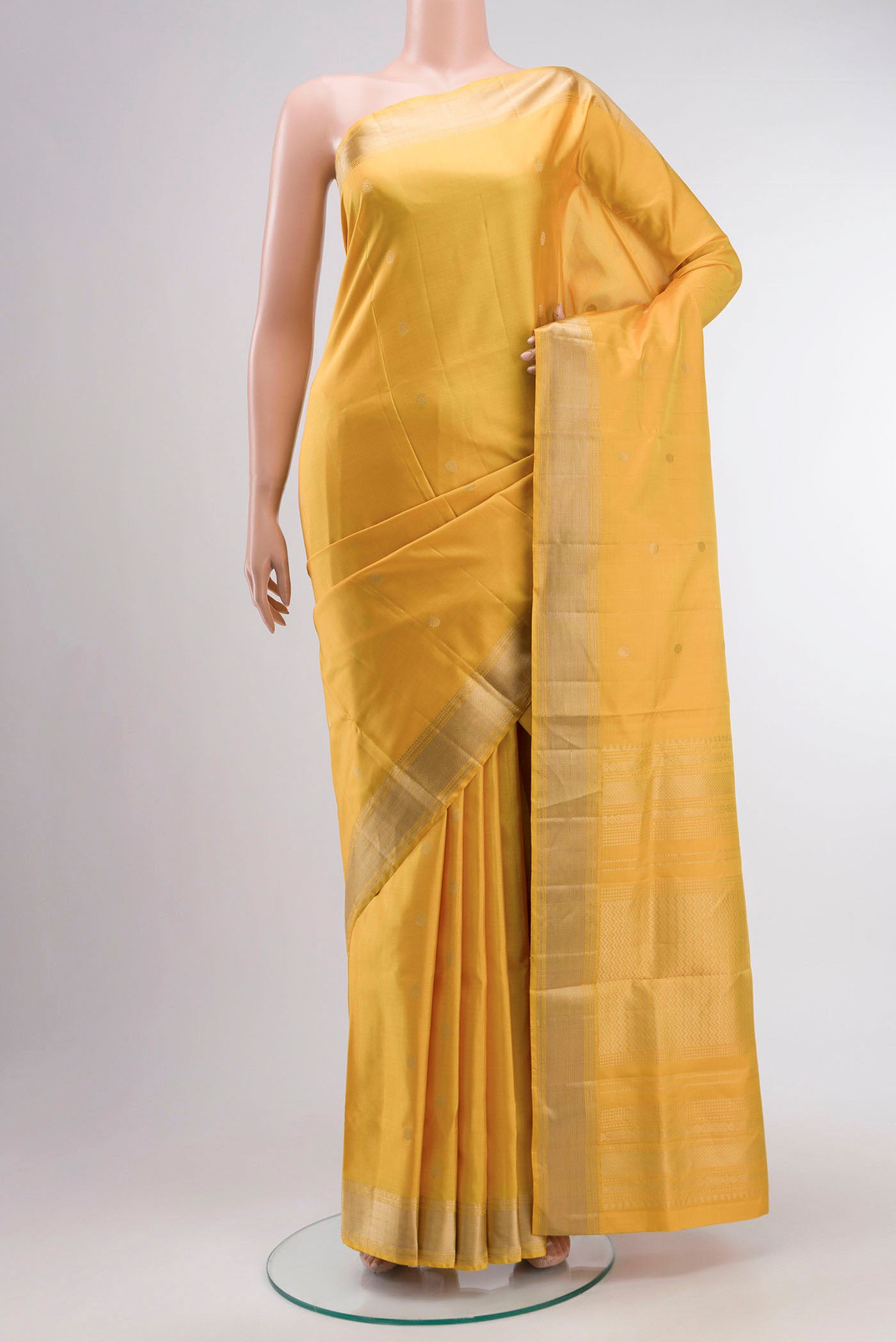 Yellow Soft Silk Saree with Zari Butta on the body and Zari Border displayed on a mannequin