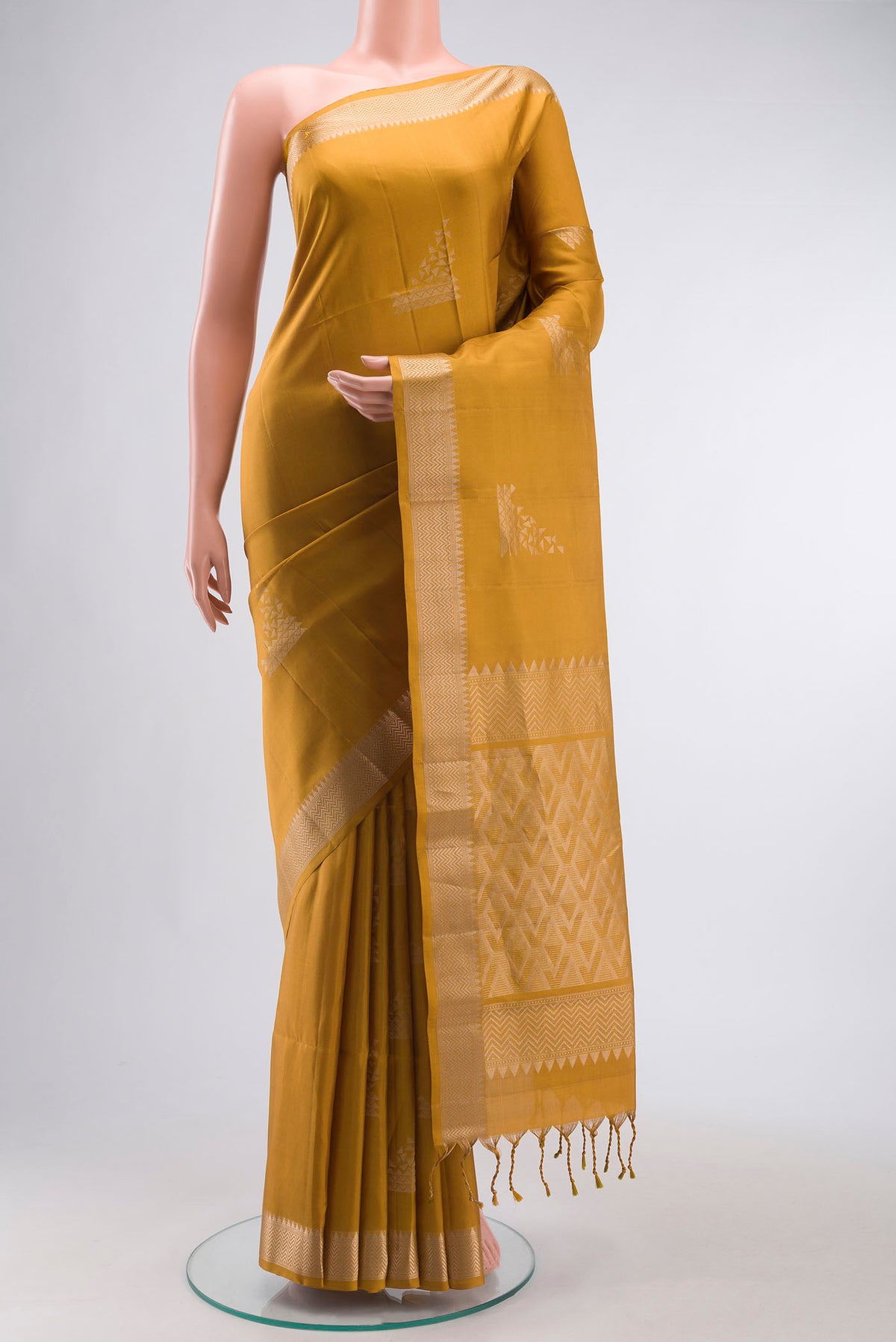 Mustard Soft Silk Saree with Zari Butta on the body and Zari Border displayed on a mannequin