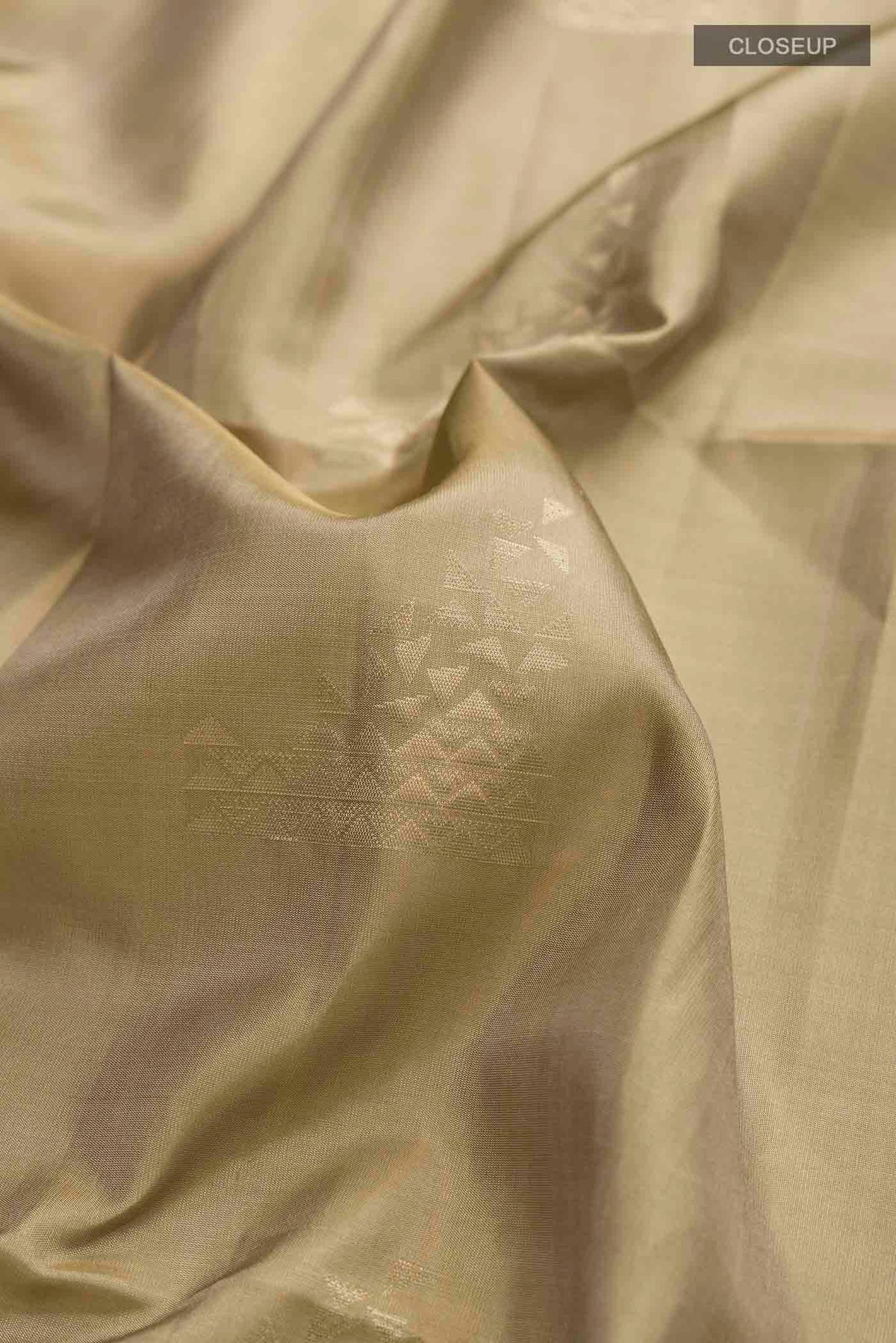 Close up of Beige Soft Silk Saree with Zari Butta on the body and Zari Border displaying folds