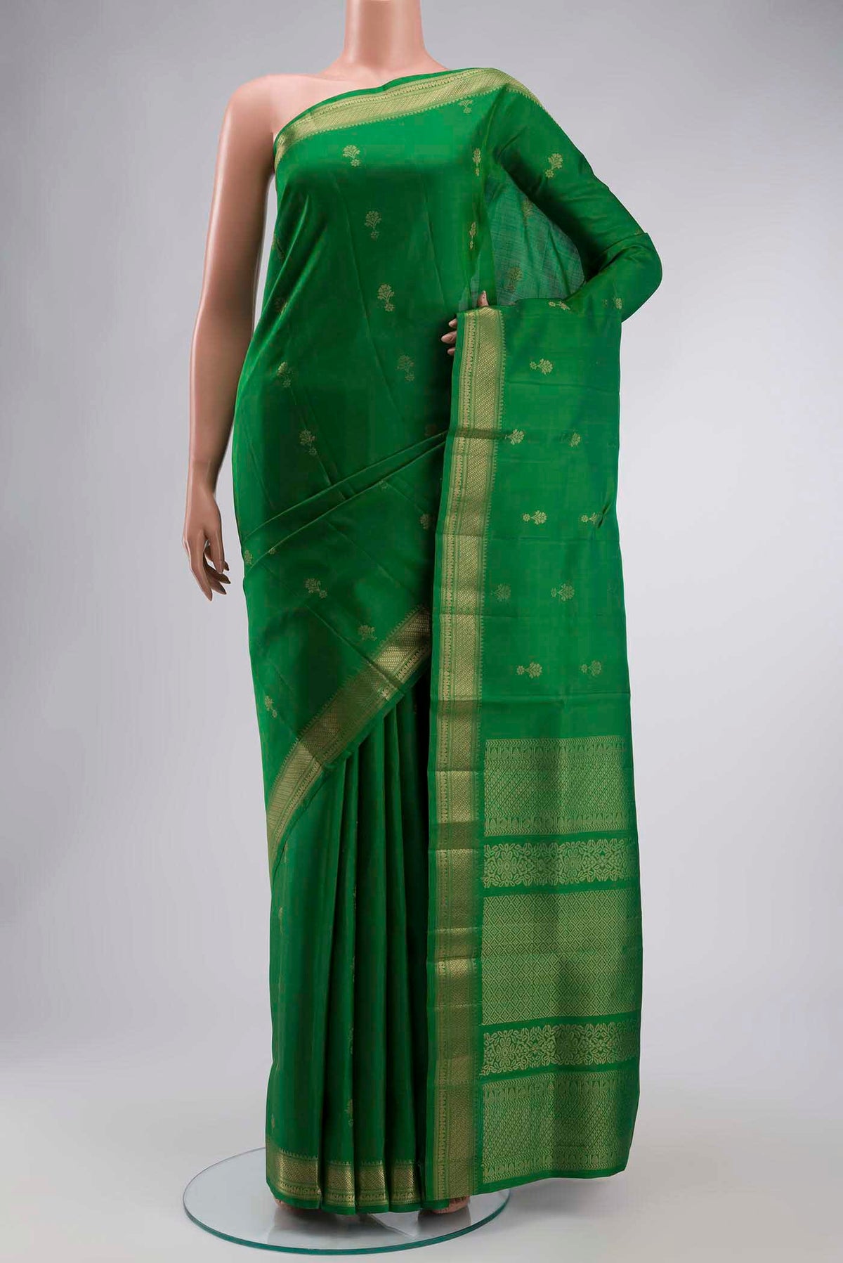 Green Soft Silk Saree with Zari Butta on the body and Zari Border displayed on a mannequin