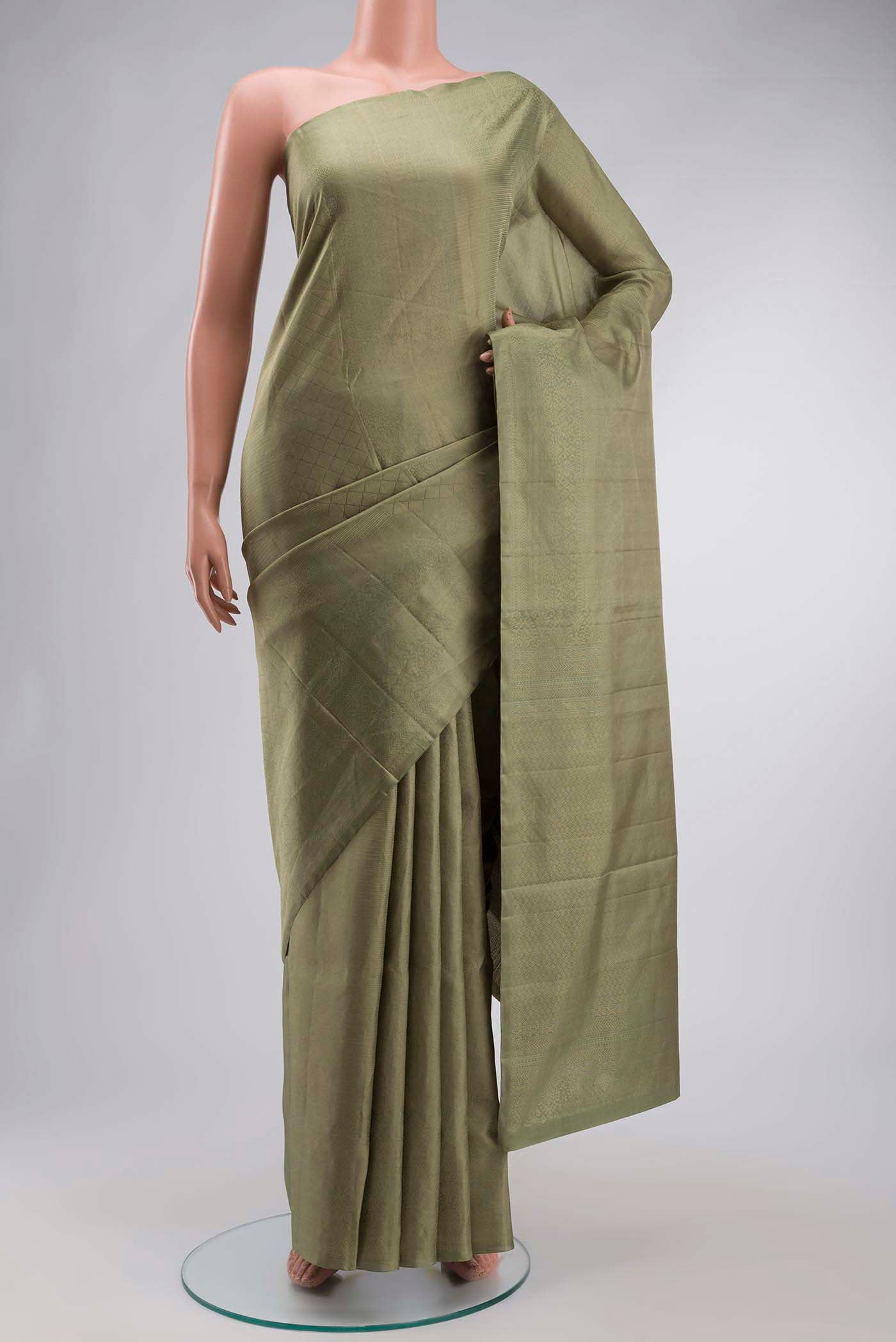 Green Soft Silk Saree with Zari Butta on the body and Zari Border displayed on a mannequin