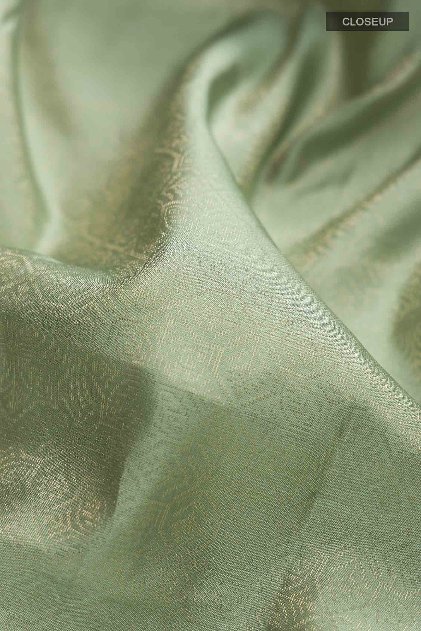 Close up of Green Soft Silk Saree with Zari Brocade on the body and Zari Border displaying folds