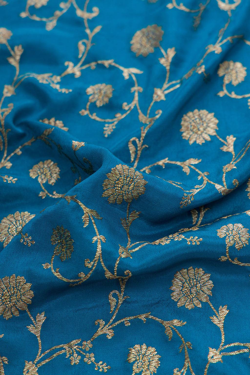 Close up of Peacock Blue Dual Tone Banarasi Georgette Saree with Zari Brocade on the body and Zari Border.  displaying folds