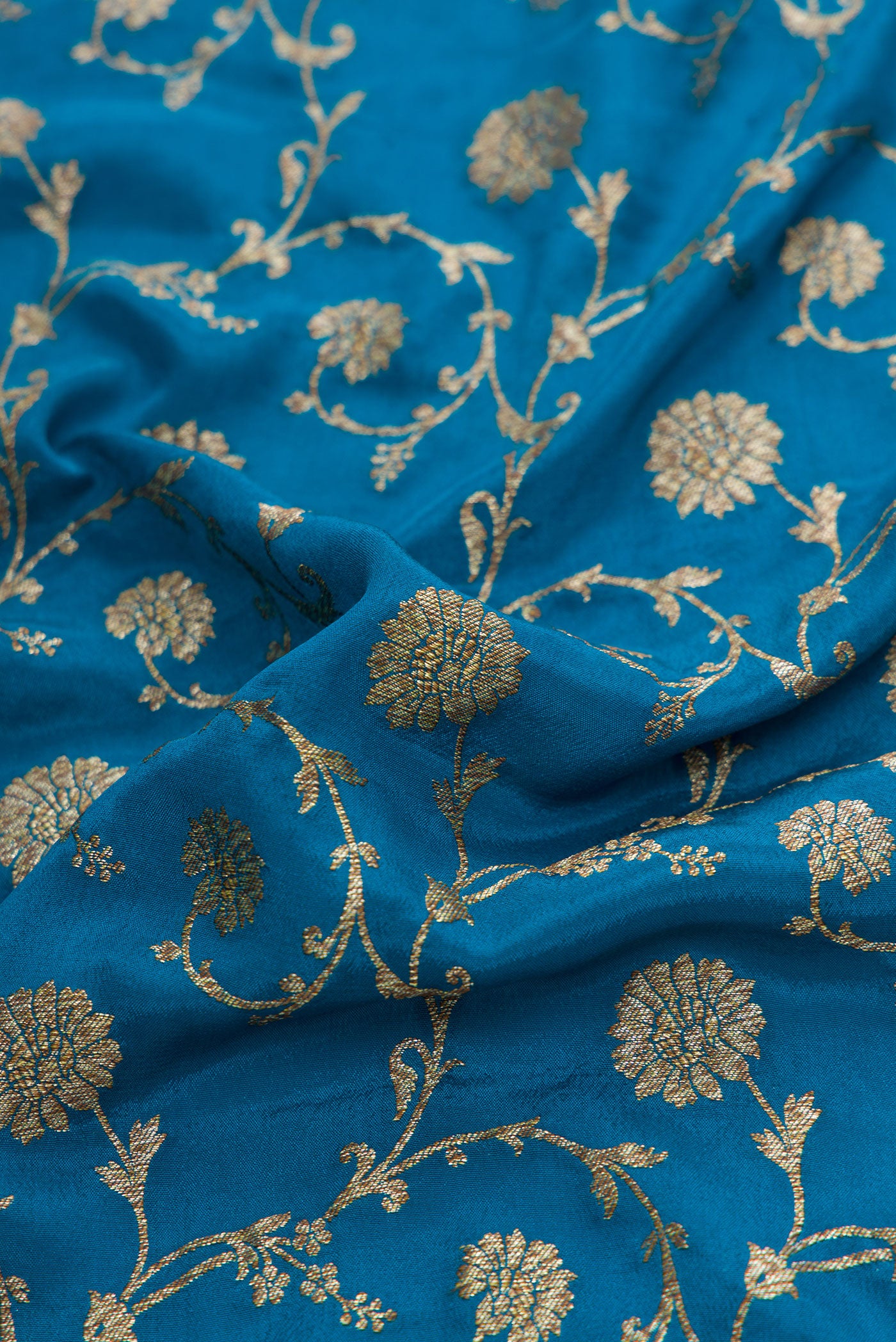 Close up of Peacock Blue Dual Tone Banarasi Georgette Saree with Zari Brocade on the body and Zari Border.  displaying folds