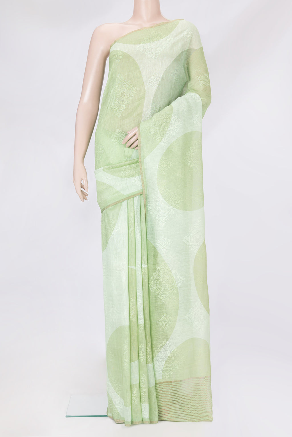 Pista Green Linen Saree with Embroidery on the body and Zari Border.  displayed on a mannequin